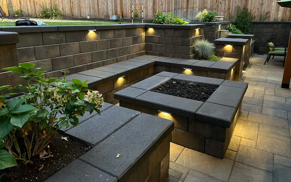 Built-in outdoor fire pit set into a lit seating wall