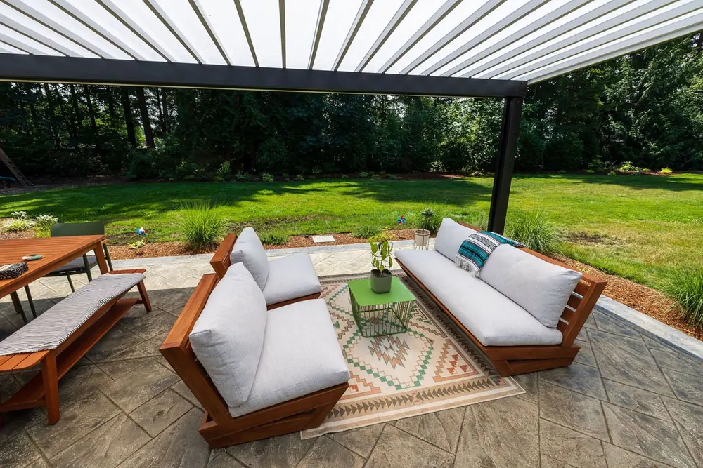 Adjustable louvered roof pergola over a paved patio